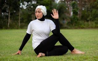 donna piacevole in hijab e abbigliamento sportivo che fa yoga e stretching. foto