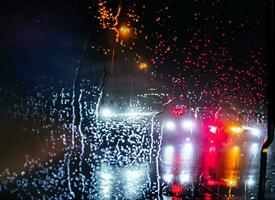 pioggia su il strada a notte con luci foto