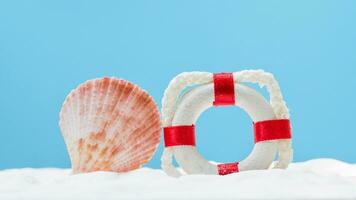 un' vita salvagente e un' conchiglia su un' blu sfondo foto