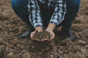 simbolo cuore terra giorno. manciata di sporco mani cuore forma. azienda agricola biologico terra. contadino mani suolo terra terra sporco giardino suolo azienda agricola terra. maschio mani pieno di fertile terra campo agricoltura concetto foto