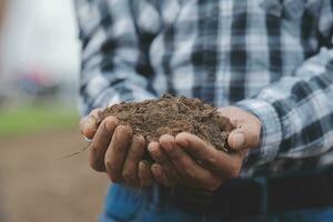 simbolo cuore terra giorno. manciata di sporco mani cuore forma. azienda agricola biologico terra. contadino mani suolo terra terra sporco giardino suolo azienda agricola terra. maschio mani pieno di fertile terra campo agricoltura concetto foto