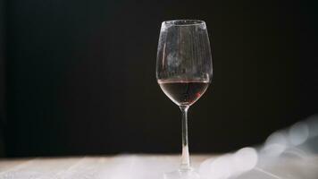 impostato di mani Tenere rosso vino bicchiere isolato su nero sfondo. foto