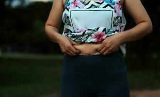 donne corpo Grasso gonfiarsi. obeso donna mano Tenere eccessivo pancia Grasso. dieta stile di vita concetto per ridurre pancia e forma su salutare stomaco muscolo. foto