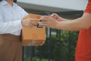 asiatico donna ricevente Prodotto a partire dal consegna uomo a casa, giovane proprietario donna ordine Prodotto a partire dal smartphone applicazione, donna con in linea attività commerciale o pmi concetto. foto