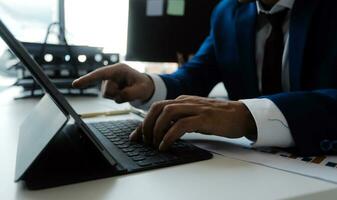 imprenditore uomo d'affari asiatico e donna d'affari che discutono di un nuovo progetto di business in tablet in una riunione moderna in un ufficio moderno, concetto casual business asiatico. foto