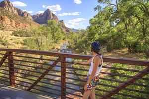 donna che guarda un fiume che scorre attraverso un canyon foto