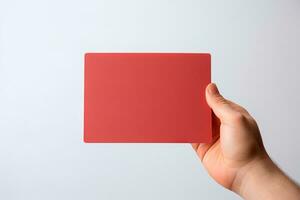 un' umano mano Tenere un' vuoto foglio di rosso carta o carta isolato su bianca sfondo. ai generato foto