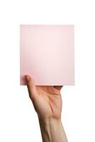 un' umano mano Tenere un' vuoto foglio di rosa carta o carta isolato su un' bianca sfondo. ai generato foto