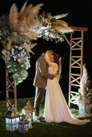 sposa e sposo contro il fondale di un sera nozze arco foto