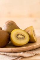 kiwi dorato fresco nel piatto di legno foto