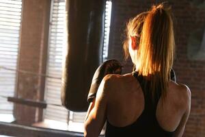 donne se stesso difesa ragazza potenza. forte donna combattente formazione pugni su boxe squillo. salutare forte ragazza punzonatura boxe Borsa. formazione giorno nel boxe palestra. forza in forma corpo allenarsi addestramento. foto