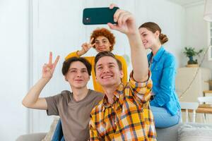 Saluti impaurito umore. contento gruppo di amici rendere autoscatto. uomo assunzione foto di amici a festa. gruppo di multirazziale giovane persone assunzione foto su Telefono. giovane persone godere loro azienda Sorridi avere divertimento.