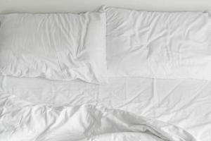 letto increspato con decorazione cuscino disordinato bianco nell'interno della camera da letto foto