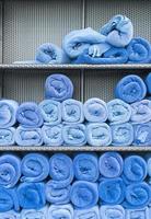 pila di rotoli di asciugamani blu sullo scaffale foto