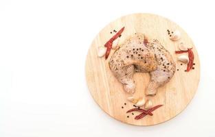 coscia di pollo marinata con salsa, peperoni neri, aglio e peperoncino essiccato su tavola di legno foto