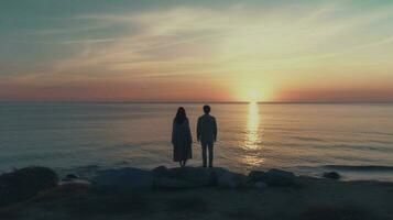 un' uomo e un' ragazza siamo guardare a il mare foto