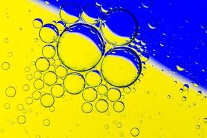 sfondo astratto di bolle d'olio sulla superficie dell'acqua tavolozza colorata blu giallo foto