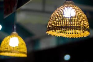 illuminazione dalla lampadina nella lampada a sospensione in tessuto di bambù foto
