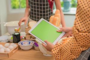 primo piano mano che tiene la tecnologia tablet nel negozio di pane foto