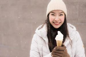donna asiatica sorride e felice con il gelato nella stagione invernale di neve? foto