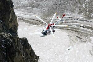 un' elicottero è volante al di sopra di un' roccioso montagna foto