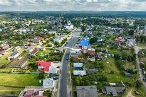 panoramico aereo Visualizza di piccolo provinciale cittadina o grande eco villaggio con di legno case, ghiaia strada, giardini e frutteti foto