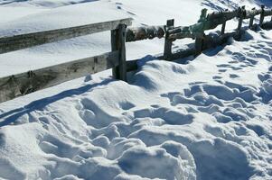 un' di legno recinto con un' neve coperto terra foto
