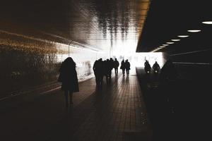 persone che camminano in controluce foto