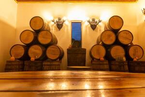 interno di vino ristorante con rustico di legno tavolo e quercia botti nel il sfondo. foto