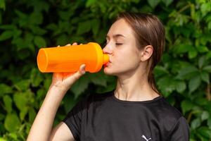 in forma locazione ragazza corridore all'aperto Tenere acqua bottiglia. foto