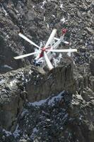 un' elicottero è volante al di sopra di un' roccioso montagna foto