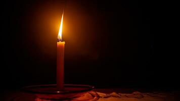 un' ardente candela contro un' buio sfondo foto