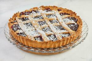 elegante delicatezza, classico linzer torta con ciliegia su marmo. delizioso tradizioni, ricoperto di ciliegia linzer torta su marmo sfondo foto