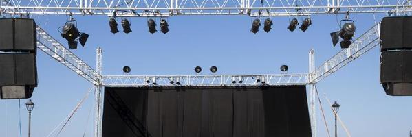 il palco con il sipario nero prima del concerto in spiaggia foto