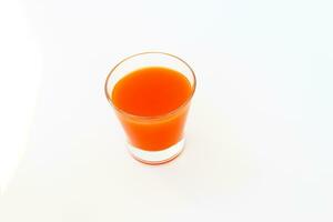 un' bicchiere di arancia succo su un' leggero sfondo foto