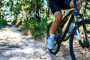 una prospettiva bassa di ciclisti di montagna su un sentiero roccioso concentrarsi sulle scarpe foto