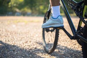 una prospettiva bassa di ciclisti di montagna su un sentiero roccioso concentrarsi sulle scarpe foto