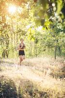 giovane donna che fa jogging sulla strada rurale nella natura della foresta. foto