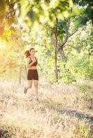 giovane donna che fa jogging sulla strada rurale nella natura della foresta. foto