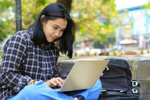 rilassare asiatico giovane donna sorridente utilizzando il computer portatile Lavorando libero professionista e contento ottenere e commercio offrire foto
