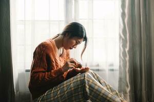 donna sedersi depressione buio dai capelli pensieroso occhiata in piedi di finestra e ansia copia spazio. foto