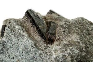 macro minerale pietra schorl, nero tormalina su bianca sfondo foto