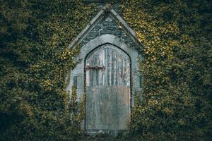 vecchio coperto di vegetazione edificio nel centro di il piccolo cittadina, llanfairfechan, nord Galles, Cymru, UK foto