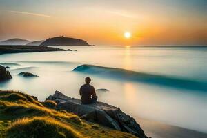 un' uomo seduta su un' roccia prospiciente il oceano a tramonto. ai-generato foto