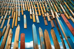 un' parete di di legno bastoni con blu cielo nel il sfondo. ai-generato foto