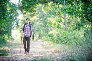 giovane uomo hipster che cammina sulla strada rurale durante le escursioni in vacanza. foto