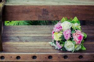 il bouquet da sposa sullo sfondo è una panca di legno foto