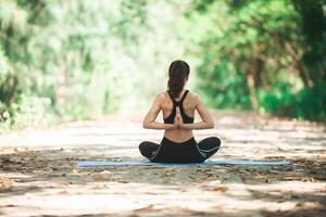 giovane donna asiatica che fa yoga al mattino al parco. sano foto