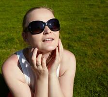 giovane donna nel occhiali da sole è prendere il sole. foto