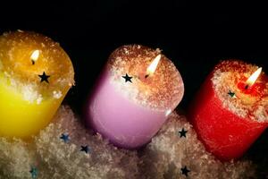 tre candele con artificiale neve. foto